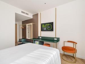a bedroom with a bed and a desk and a chair at B&B HOTEL Catania Bellini in Catania