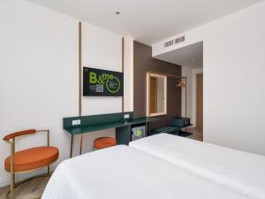 a bedroom with a bed and a desk and chair at B&B HOTEL Catania Bellini in Catania