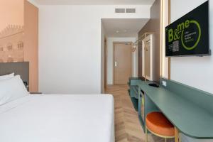 a hotel room with a bed and a desk and a bed sidx sidx at B&B HOTEL Catania Bellini in Catania