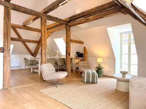 an attic living room with wooden beams and chairs at HyggeLiving - 120qm - Boxspringbetten - 55" Smart TV - Küche - Parkplatz - bis 8 Pers - BESTLAGE in Wernigerode