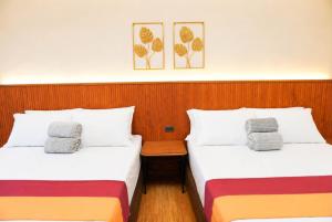 two beds sitting next to each other in a room at Starhomes Hotel & Cafe in Tarlac
