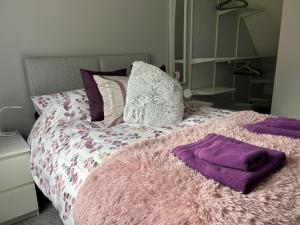 a bed with a pink blanket and pillows on it at Captivating 1-Bed Apartment in Hednesford in Cannock