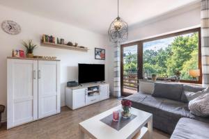 a living room with a couch and a tv at Ferienwohnung Talblick in Medebach
