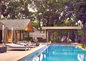 a swimming pool with lounge chairs and a pavilion at Villa Escape Burasari in Phuket