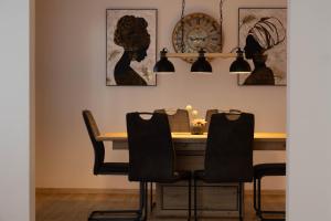 a dining room with a wooden table and black chairs at Ferienwohnung am Waldweg in Kolsass