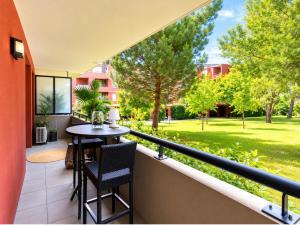 a balcony with a table and chairs and a garden at Appartement luxury in Montpellier