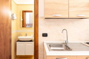 a small kitchen with a sink and a mirror at Lu Marchese in Minervino di Lecce +23 photos