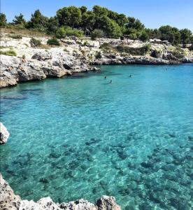 a group of people swimming in a body of water at Lu Marchese in Minervino di Lecce