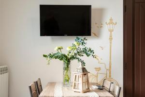 a vase of flowers on a table with a tv at Lu Marchese in Minervino di Lecce