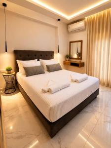 a bedroom with a large bed with towels on it at Our Villa - Villa Rena in Rethymno
