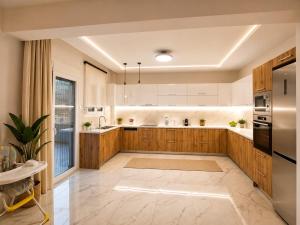 a large kitchen with wooden cabinets and a refrigerator at Our Villa - Villa Rena in Rethymno
