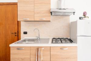 a kitchen with a sink and a refrigerator at Lu Marchese in Minervino di Lecce