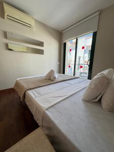 two beds in a room with a window at ACP Cambrils Puerto Apartamentos in Cambrils