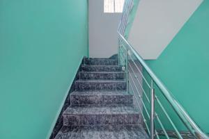 a staircase in an office building with blue ceilings at Hotel O City View in Dānāpur