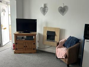 a living room with a tv and a chair at Captivating 1-Bed Apartment in Hednesford in Cannock