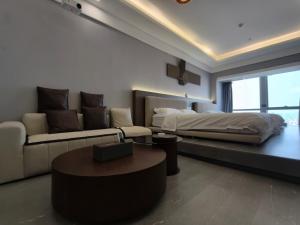 a living room with a couch and a bed at High Clouds Hotel Apartment in Guangzhou