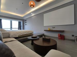 a living room with a couch and a projection screen at High Clouds Hotel Apartment in Guangzhou