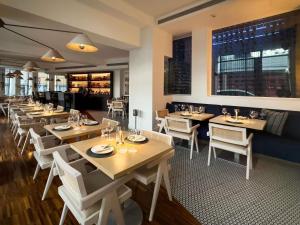 a restaurant with wooden tables and white chairs at The Classic Hotel Nicosia - Handwritten Collection in Nicosia