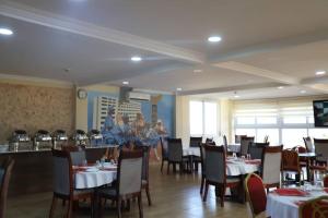 a restaurant with tables and chairs and people in the background at Nyansapo Eco Resort in Cape Coast