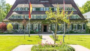 a large house with flags in front of it at Hotel Döllnsee-Schorfheide in Templin