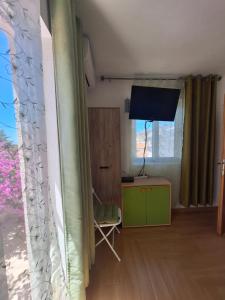 a living room with a green cabinet and a television at Villa Lyudmila in Utjeha
