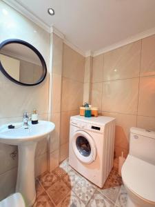 a bathroom with a washing machine and a sink at Premier Sea Apartment in Paleo Tsifliki +23 photos