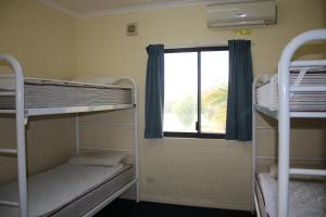a room with two bunk beds and a window at Ningaloo Coral Bay Backpackers in Coral Bay