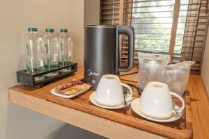 a coffeemaker sitting on a counter with two mugs at Baanna Place in Ban Na