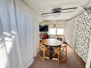 a small dining room with a table and a window at Guest House モモ in Obihiro
