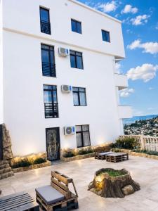 a white building with benches in front of it at Panorama Hills Apart-Hotel in Tbilisi City
