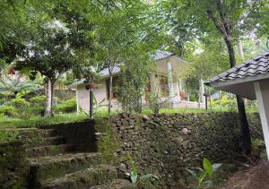 a small house behind a stone wall with a house at Sumeru valley vagamon in Idukki +27 photos