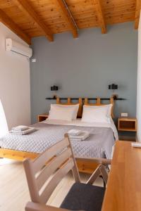 a bedroom with a bed with two chairs and a table at ELÉA Guesthouse himare in Himare