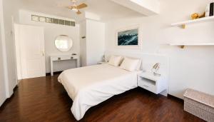 a white bedroom with a white bed and a mirror at Brisa Vacacional - Adults Only in Corralejo +28 photos
