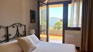 a bedroom with a bed and a door to a balcony at iH Hotels Le Zagare Resort in Villasimius +36 photos