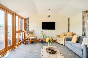 a living room with a couch and a tv at The Barn in Corwen
