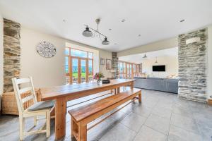 a dining room with a wooden table and chairs at The Barn in Corwen