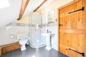 a bathroom with a shower and a toilet and a sink at The Barn in Corwen +76 photos