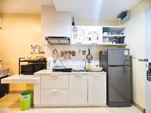 a kitchen with white cabinets and a stainless steel refrigerator at The Beach Bangsaen Condo 327/30 in Ban Bang Saen (1)