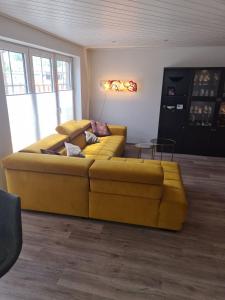 a large yellow couch in a living room at Ferienwohnung Grahn 15154 in Leer