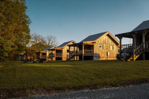 a group of wooden houses on a grass field at Peaceful Creekside Tiny Cabin, Family Adventure Near Waterfalls in Smithville