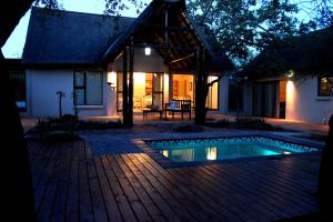 a house with a swimming pool in front of a house at Switsongo Boutique B&B in Hoedspruit