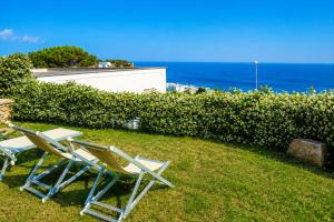 two chairs sitting on the grass near the ocean at Maridea - Ondine in Ponza