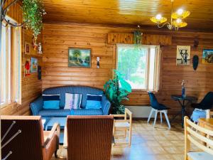 a living room with a blue couch in a wooden room at Toivola , Joroinen in Joroinen