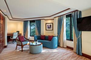 a living room with a blue couch and a table at Nairobi Serena Hotel in Nairobi
