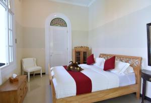 a bedroom with a bed with a cat sitting on it at Villa Mimosa in Lovina