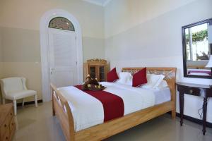a bedroom with a bed with a stuffed animal on it at Villa Mimosa in Lovina