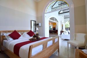 a bedroom with a large bed and a chair at Villa Mimosa in Lovina