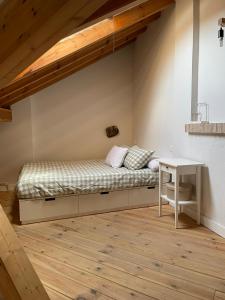 a bed in the corner of a room with a table at El Rincón de la Plazuela in Romancos