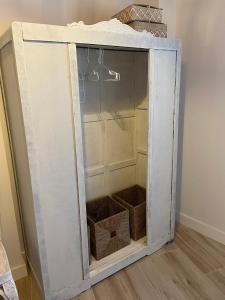 a white cabinet with two baskets inside of it at El Rincón de la Plazuela in Romancos +27 photos