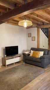 a living room with a couch and a flat screen tv at El Rincón de la Plazuela in Romancos